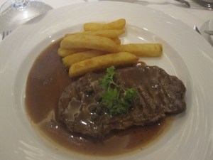 Grilled Grass-Fed Sirloin Steak with French Fries and Creamy Green Peppercorn Sauce.