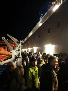 Passengers waiting on the open decks for further information following the fire in a passenger cabin